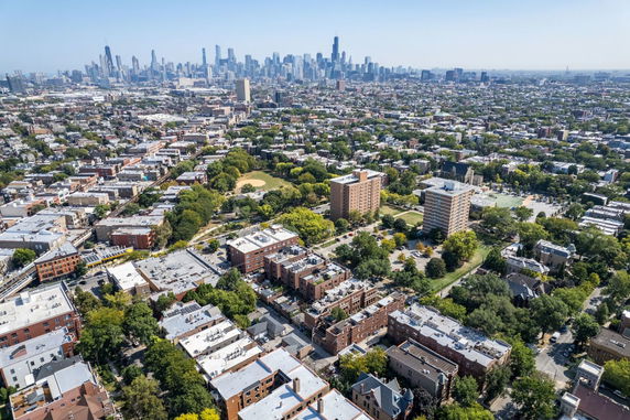Panoramic view of a cityscape with numerous buildings and a distant skyline.