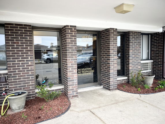 Front view of a brick building with a glass entrance door.