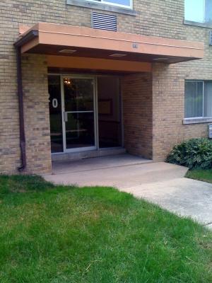 Front view of a building entrance with a glass door and small canopy.