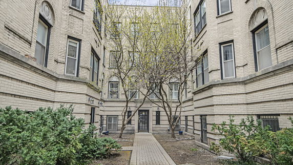 Front view of a multi-story brick building with large windows and a central entrance.