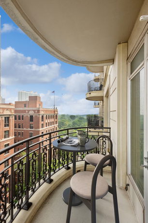 Balcony view from a high-rise building showcasing nearby architecture and parkland.