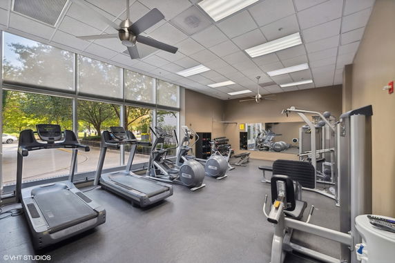 Indoor gym area with exercise equipment and large windows.