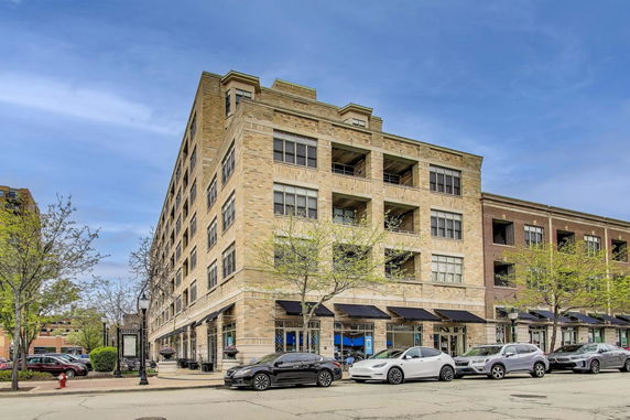 Front view of a multi-story building with retail spaces on the ground floor.