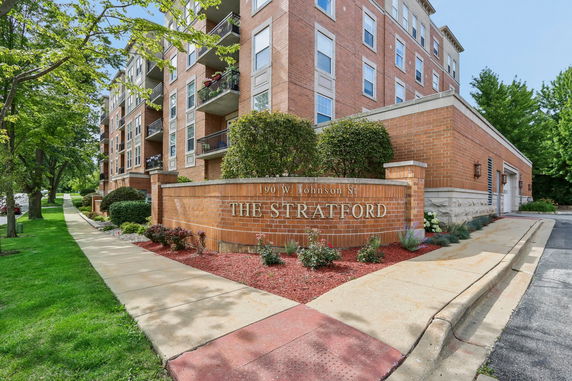 Front view of an apartment building with a brick facade and balconies.