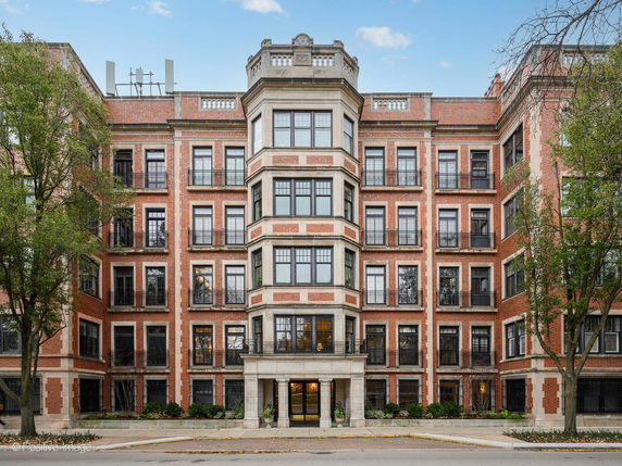 Front view of a multi-story brick building with multiple windows and a central entrance.