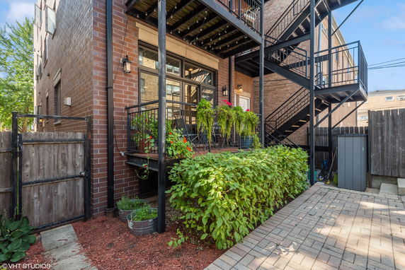Side view of a brick building with a balcony and external staircase.