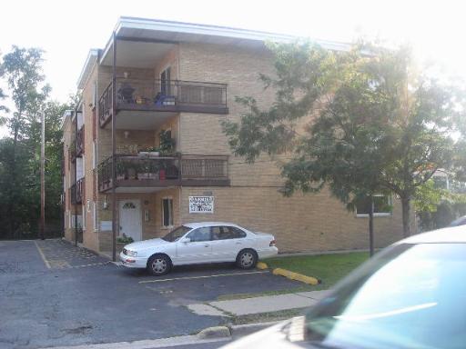 Front view of a three-story apartment building with balconies.