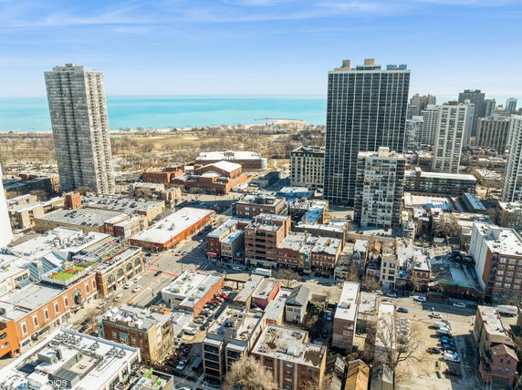 Panoramic view of a cityscape with tall buildings and a lake in the background.