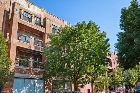 Front view of a multi-story brick building with balconies.