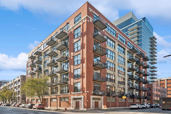 Front view of a multi-story brick apartment building with balconies.