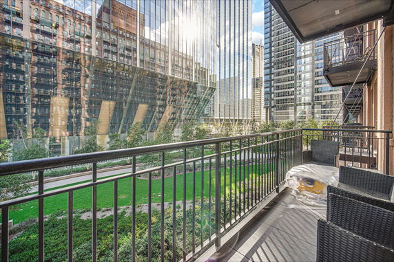 Panoramic view from a balcony overlooking modern skyscrapers and greenery.