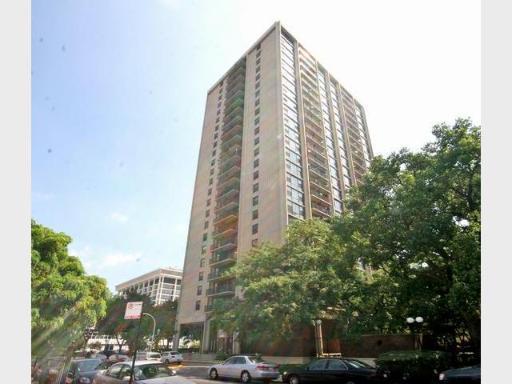 Front view of a tall apartment building with multiple stories in an urban setting.