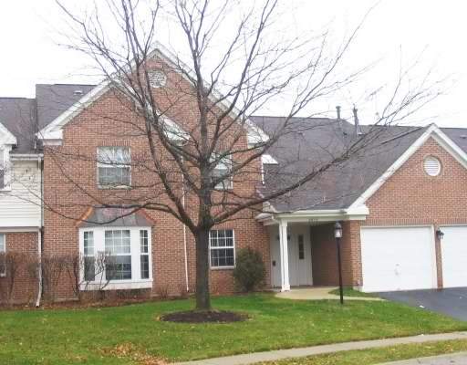 Front view of a two-story brick house with a garage.
