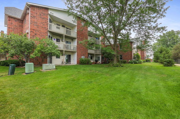 Front view of a multi-story brick building with balconies.