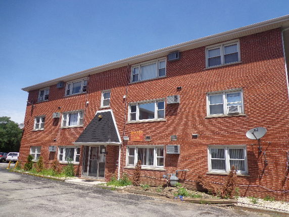 Front view of a three-story brick apartment building.