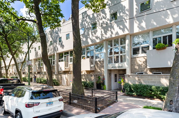Front view of a modern multi-story building with large windows and balconies.