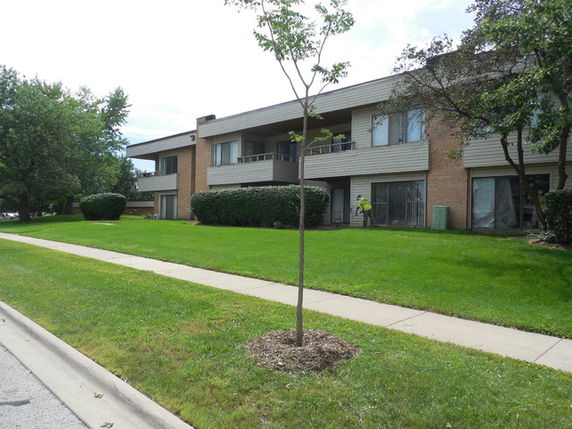 Front view of a two-story apartment building with balconies.
