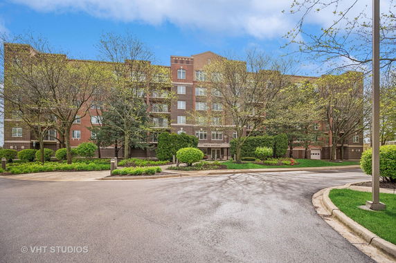 Front view of a multi-story brick residential building with balconies.