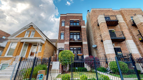 Front view of a multi-story brick building with balconies.