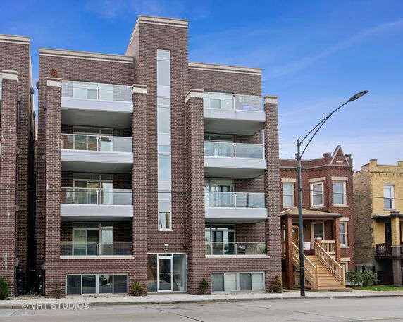 Front view of a multi-story apartment building with balconies.