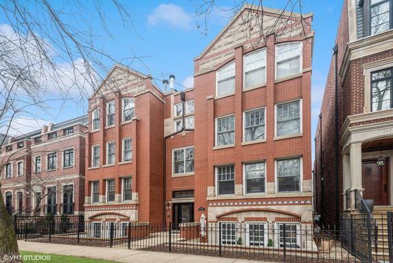 Front view of a multi-story brick building with large windows.