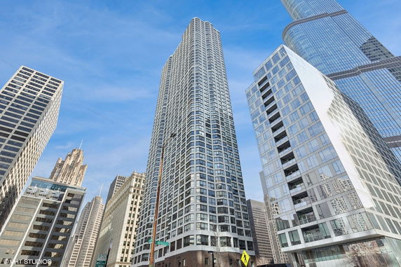 Front view of a tall skyscraper among other high-rise buildings.