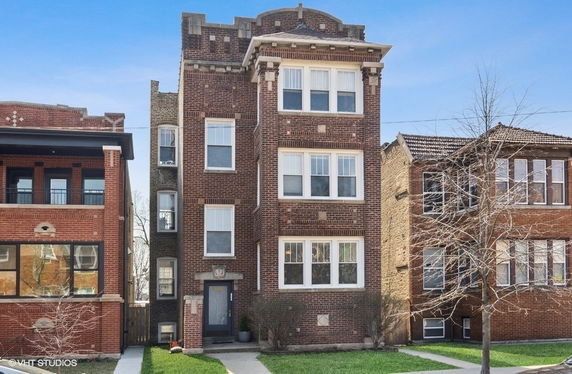 Front view of a multi-story brick building with multiple windows.