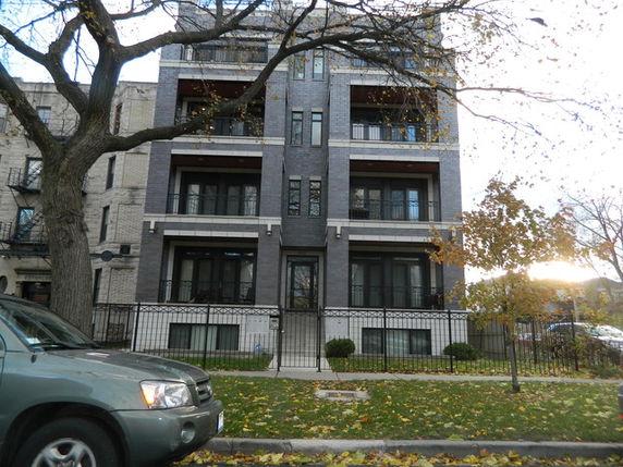 Front view of a multi-story residential building with balconies.