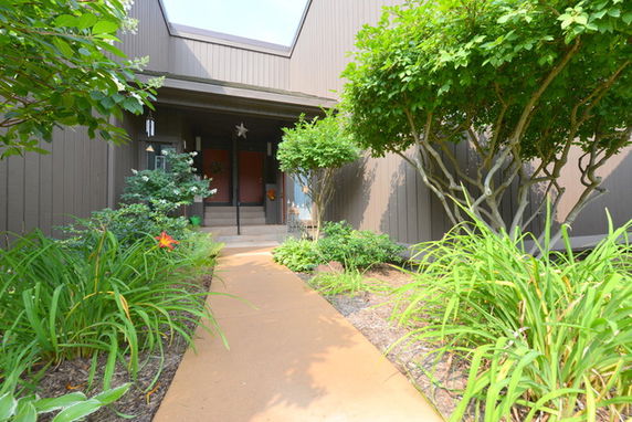 Front view of a house with a pathway leading to the entrance.