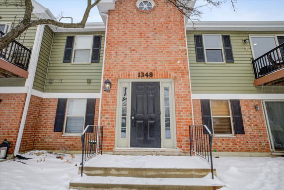 Front view of a two-story house with brick and siding exterior