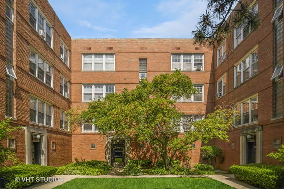 Front view of a brick apartment building with multiple entrances.