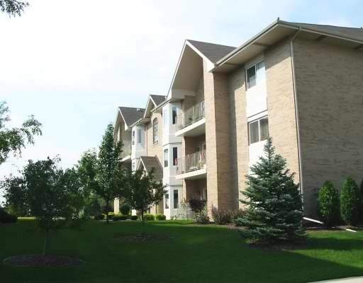 Front view of a multi-story apartment building with balconies.