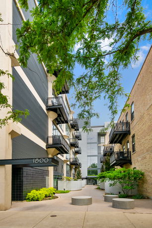 Front view of an apartment building with balconies and a prominent entrance marked '1800'.