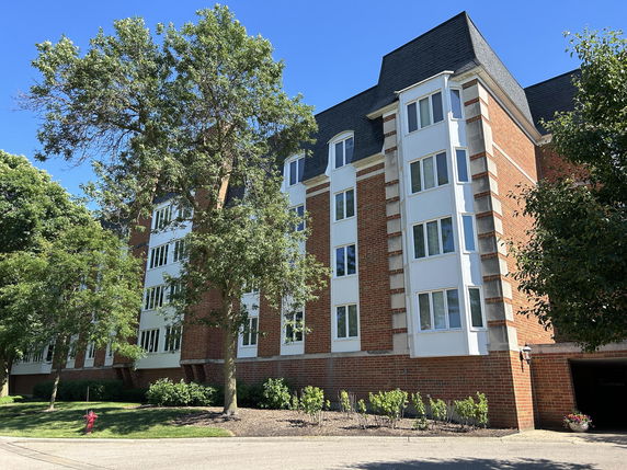 Front view of a multi-story brick building with bay windows.