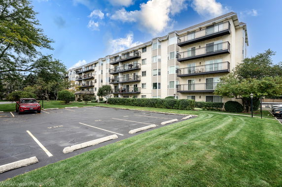 Front view of a multi-story apartment building with balconies.