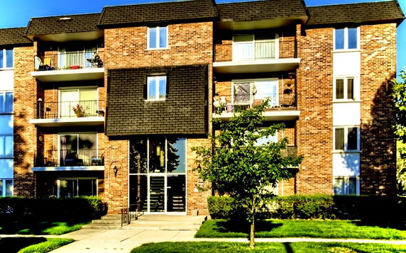 Front view of a multi-story apartment building with balconies.
