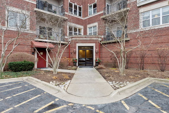 Front view of a brick building with balconies and entrance.