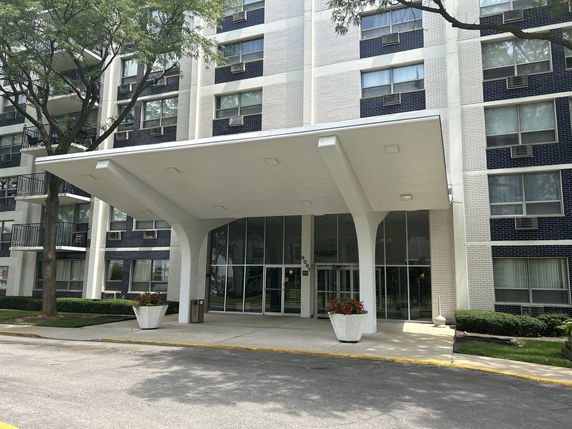Front view of a multi-story building entrance with a covered canopy.