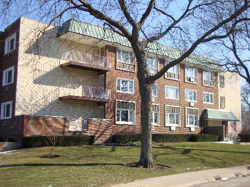 Front view of a multi-story apartment building with balconies.