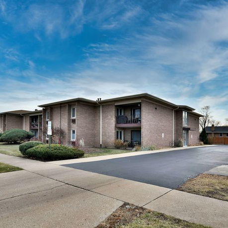 Front view of a two-story apartment building with a sloped roof.
