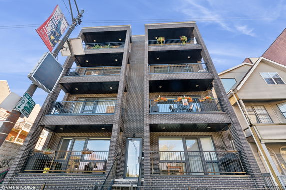 Front view of a multi-story brick building with balconies.