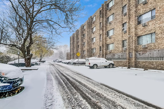 Front view of a multi-story brick building with snow-covered surroundings.