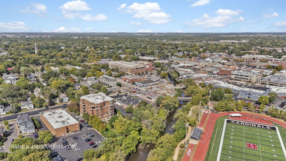 Aerial view of a town with a football field labeled 'Cardinals' and surrounding buildings and greenery.