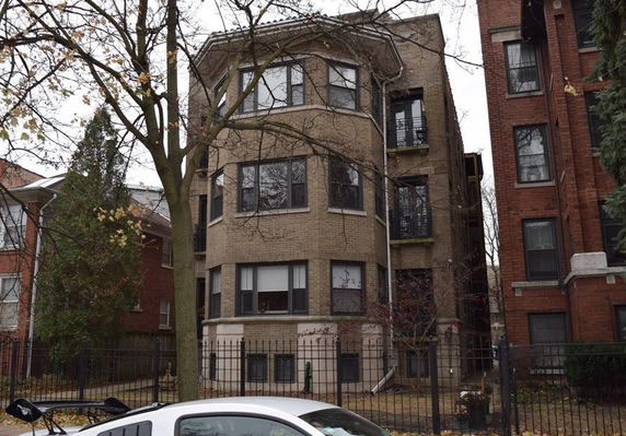 Front view of a multi-story brick apartment building.