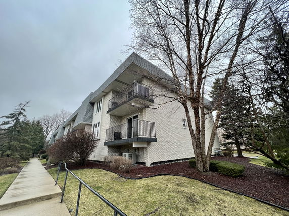Front view of a multi-story residential building with balconies.