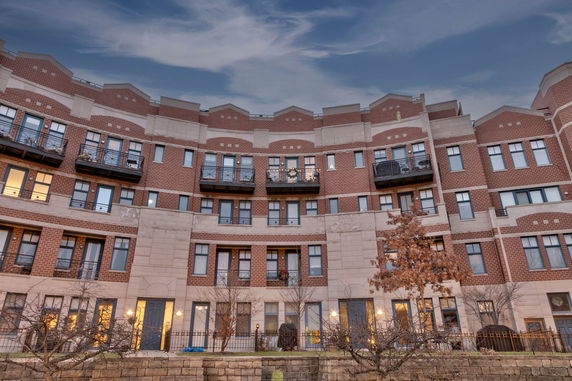 Front view of a multi-story brick apartment building with balconies.