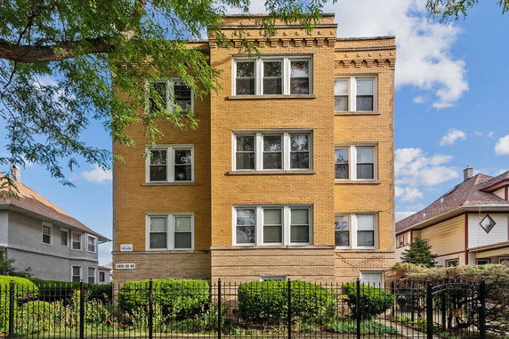 Front view of a four-story brick apartment building.