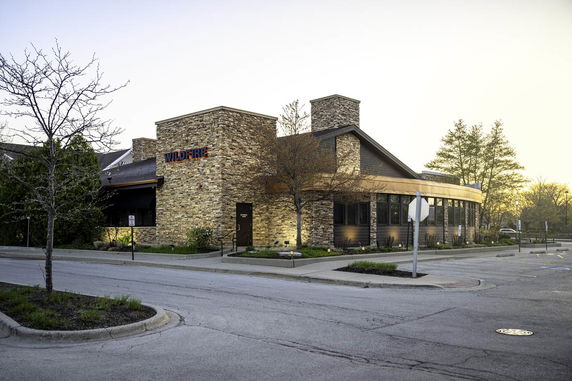 Front view of a single-story commercial building with stone facade and large windows.