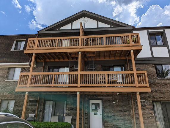 Front view of a multi-story building with balconies and brick facade.