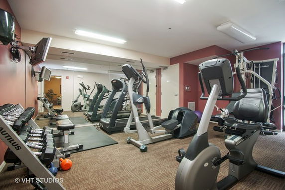Recreation area with exercise equipment and mirrored wall.